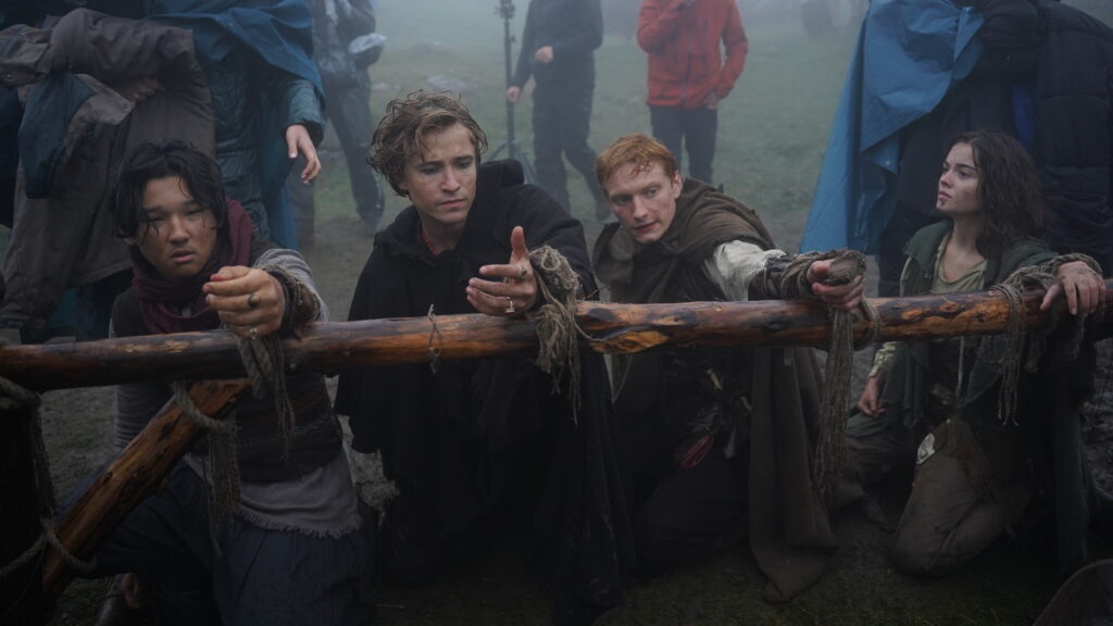 Czworo młodych bohaterów o brudnych twarzach, przywiązanych do drewnianej bariery w mglisty dzień - kadr z filmu "Dziki" (reż. Maciej Kawulski).